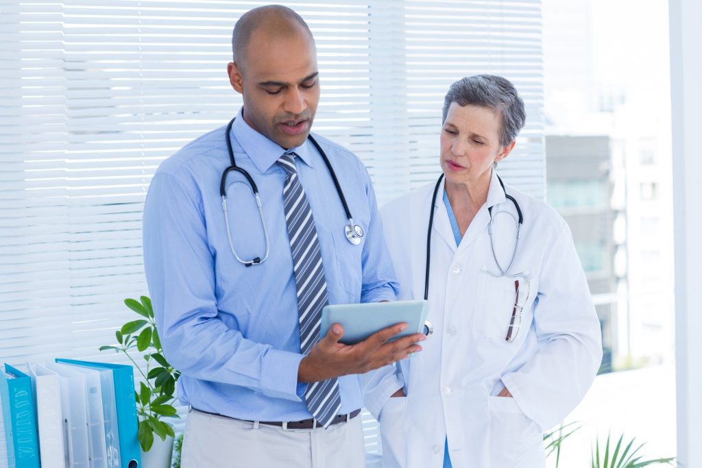 Medical colleagues with tablet computer discussing their ehr vendor