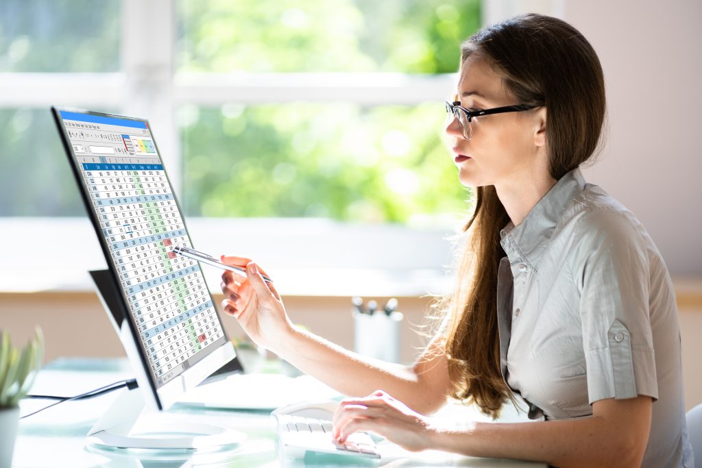 Medical biller looking a screen in a sunny doctors office