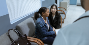 Payer mix healthcare represented by one woman consoling another in a waiting room